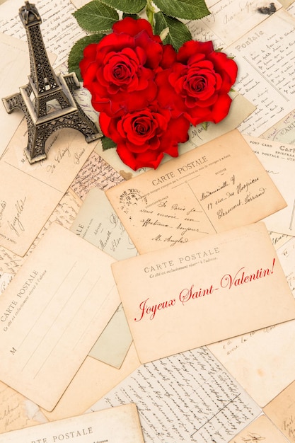 Rosas, cartões postais vintage e lembranças da Torre Eiffel de Paris. Texto de exemplo Happy St. Valentin em francês