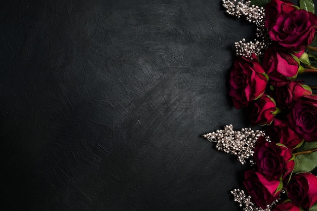 Rosas de color burdeos o rojo vino y decoración plateada sobre fondo oscuro. Verdadero amor pasión y deseo. Copie el concepto de espacio