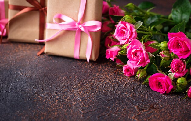 Rosas cor de rosa e caixas de presente com fitas