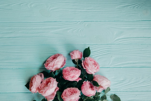 Rosas cor de rosa em uma mesa azul, conceito de verão