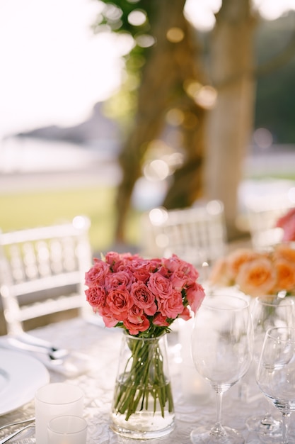 Rosas cor de rosa em uma mesa decorada para uma recepção de casamento