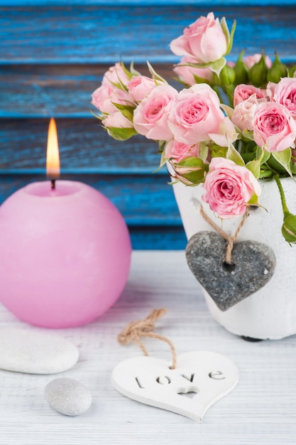 Rosas cor de rosa em vaso de concreto com vela