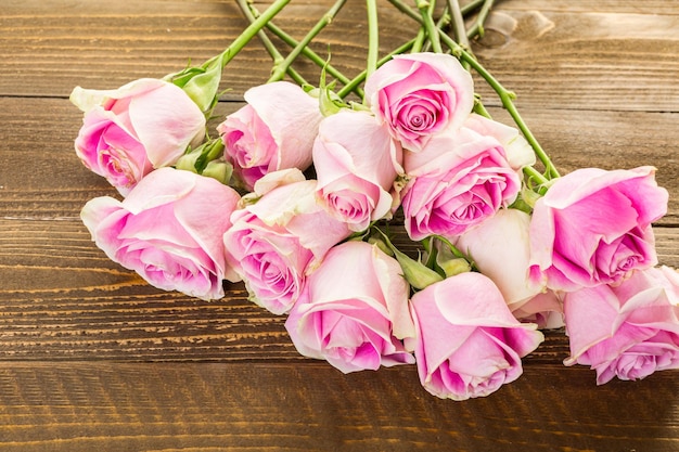 Foto rosas cor de rosa na mesa de madeira.