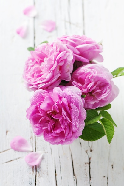 Foto rosas cor de rosa na mesa de madeira