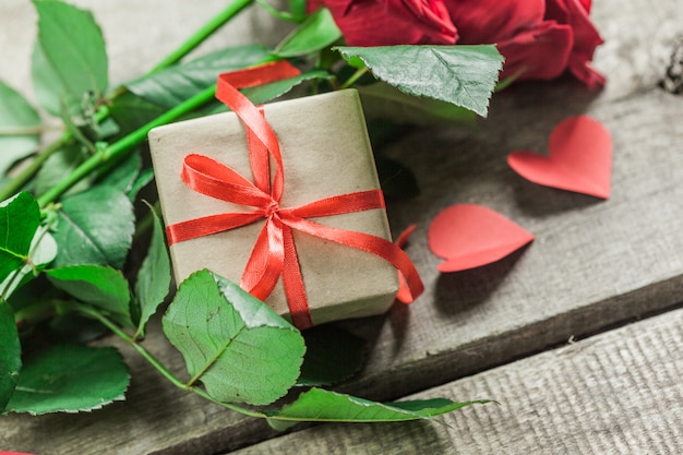 Rosas y corazones sobre tabla de madera, fondo del día de San Valentín