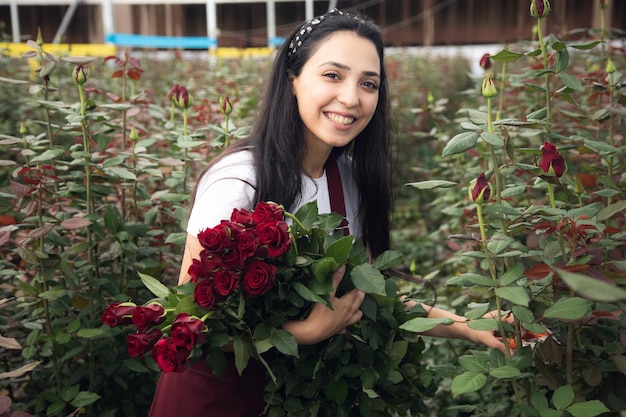 Rosas de mão de mulher trabalhadora em estufa