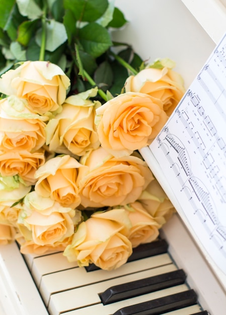 Rosas de pêssego no piano com notas