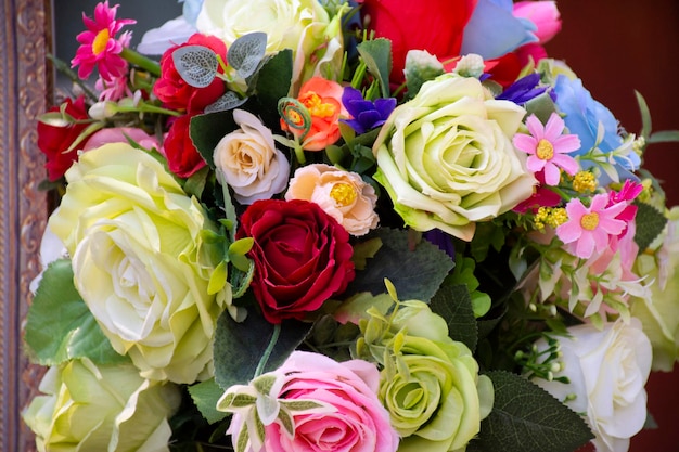 Rosas de plástico coloridas e outras flores para decoração e móveis no jardim ao ar livre