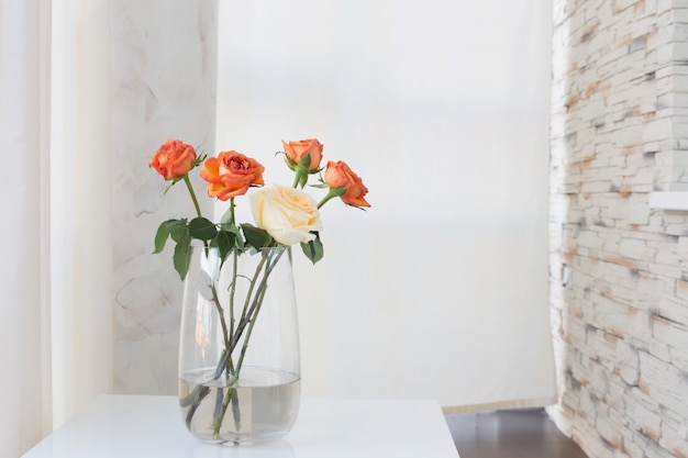 Rosas en florero sobre mesa blanca