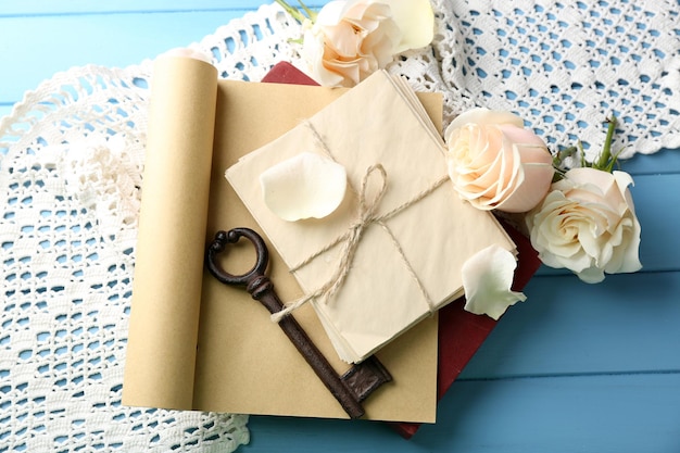 Rosas frescas com um livro velho e letras no fundo da mesa de madeira de cor. Conceito vintage