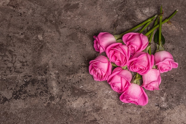 Rosas frescas em fundo de concreto de pedra texturizado. Cartão de felicitações para casamentos, aniversários, 8 de março, dia das mães ou dos namorados