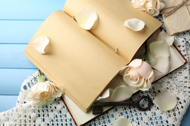 Rosas frescas con libro antiguo y letras sobre fondo de mesa de madera de color. concepto de la vendimia