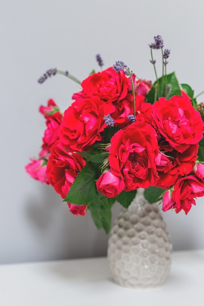 Rosas de jardín en un jarrón gris en un interior minimalista primavera fondo rústico con delicada floración