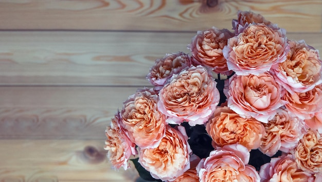 Rosas laranja em uma velha mesa de madeira marrom com espaço de cópia