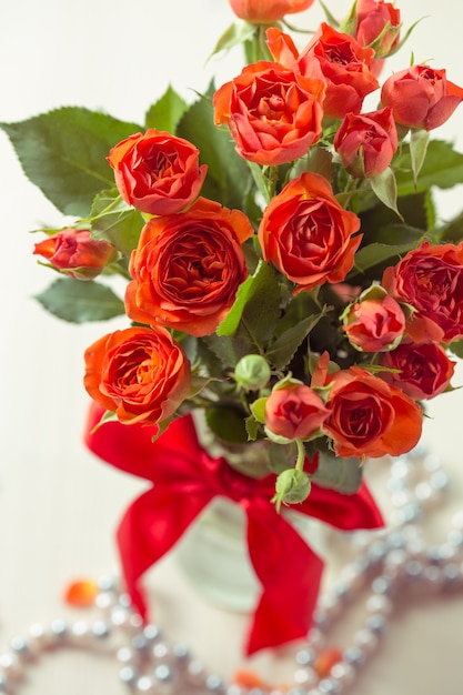 Foto rosas naranjas en florero.