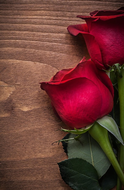 Rosas naturales aromáticas expandidas en concepto de vacaciones de tablero de madera