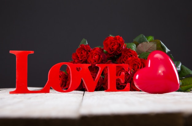 Rosas rojas, corazón y signo de amor