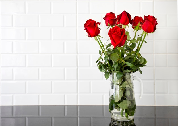 Foto rosas rojas en una jarra de vidrio