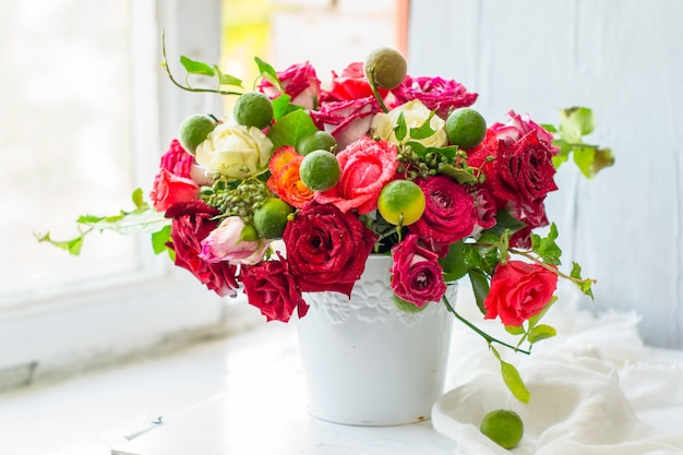 Foto rosas rojas en un jarrón blanco