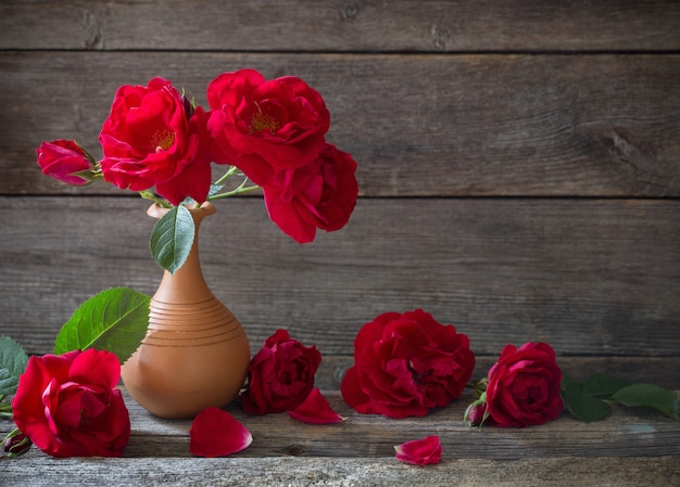 Rosas rojas en la mesa de madera