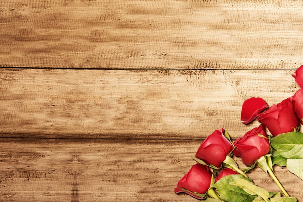 Rosas rojas en una mesa de madera