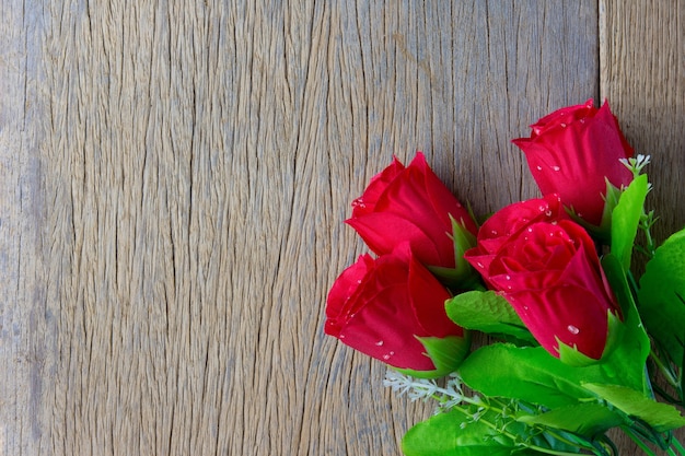 Rosas rojas y sobre fondo de madera. Vista superior con espacio de copia, conceptos de San Valentín.