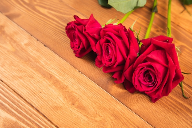 Rosas rojas sobre superficie de madera