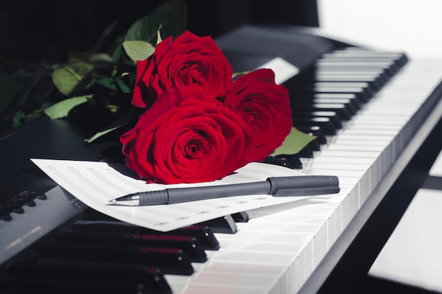 Rosas rojas en las teclas del piano