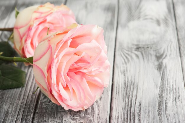 Rosas rosadas en mesa de madera