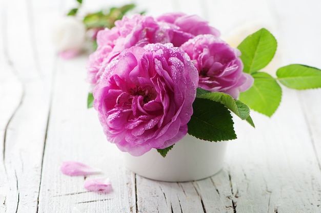 Rosas rosadas en la mesa de madera