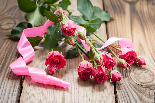 Rosas rosadas en una mesa de madera