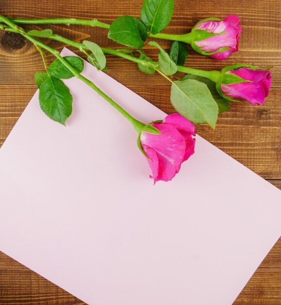 Foto rosas rosadas sobre fondo de madera beige