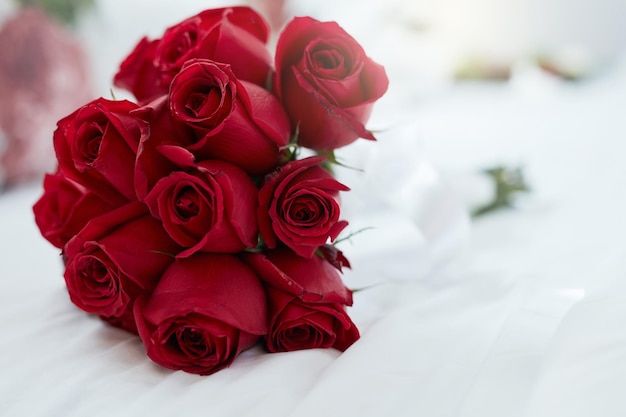 Las rosas son rojas y el amor es para siempre Disparo de un ramo de rosas rojas sobre una cama