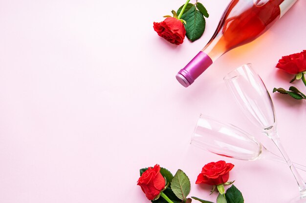 Rosas vermelhas, copos e garrafa de vinho
