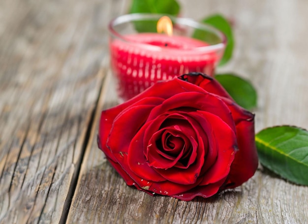 Rosas vermelhas e uma vela em uma mesa de madeira