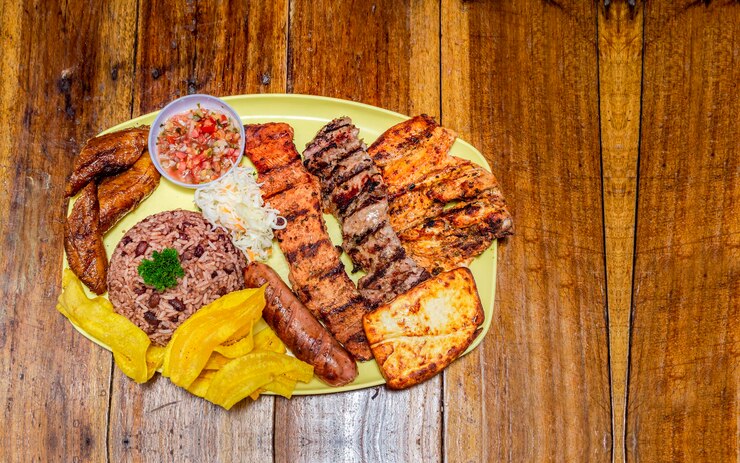 Foto rosbife com arroz frito, queijo e salada de tomate comida da nicarágua servida em mesa de madeira
