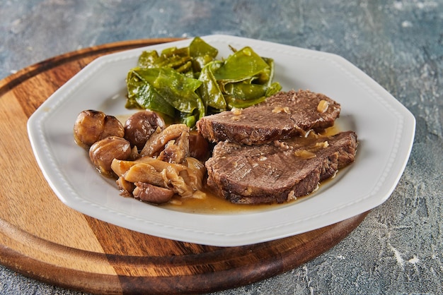 Foto rosbife com castanhas e cogumelos florestais e ervilhas verdes comida gourmet francesa