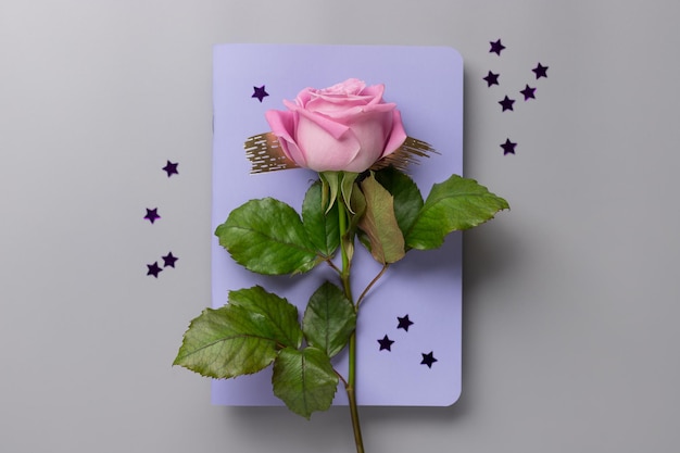 Rose Flower Violet Notebook und Sternen Konfetti auf grauem Schreibtisch Farbe des Jahres 2022 Very Peri