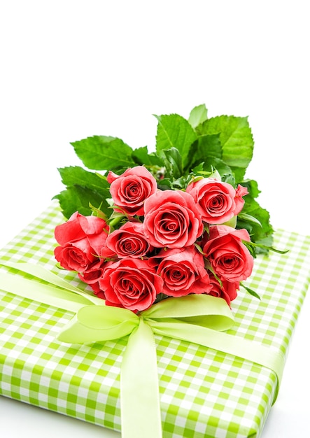 Rosen mit Geschenk auf weißem Hintergrund. pinke Blumen. romantisches Blumenarrangement. selektiver Fokus