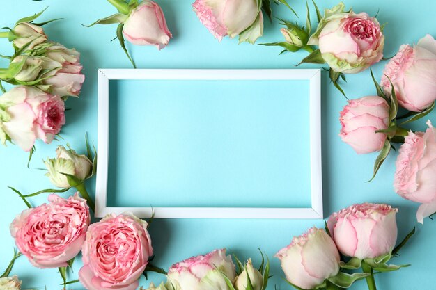 Rosen und leerer Rahmen auf blau