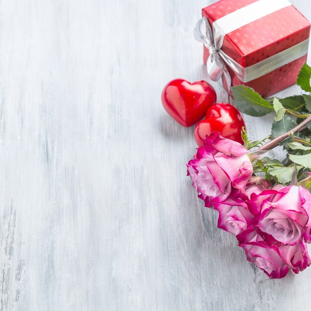 Roses. rosas cor de rosa com dois corações e presente vermelho.