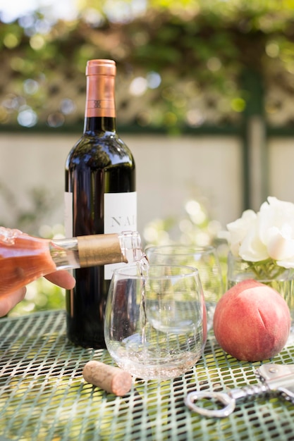 Roséwein wird aus einer Weinflasche in ein Glas gegossen