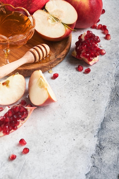 Rosh Hashaná Manzanas de granada y productos tradicionales de miel para la celebración en un fondo gris rústico Celebración judía de Rosh Hashaná en otoño Fiesta judía Diseño de Rosh Hashaná Enfoque selectivo