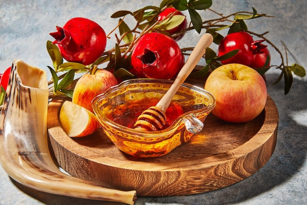 Rosh Hashanah conceito de feriado de ano novo judaico Bowls em forma de maçã com maçãs de mel romã shofar em um fundo azul