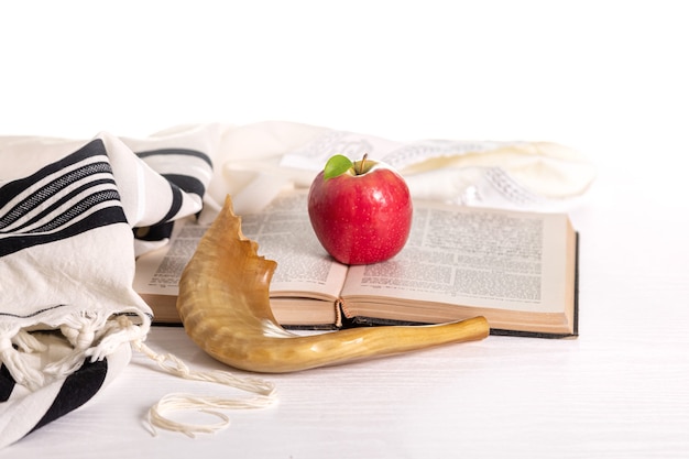 Rosh Hashanah. Yom Kippur. Tallit, shofar, torá, maçã vermelha em um fundo branco. Isolado