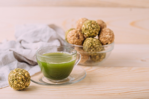 Rosinen Mandelhonig Glückskugeln. Gesunde Haferflocken-Snacks Energy Balls mit Hafer-Mandel-Butter und Honig. Tasse Matcha-Tee