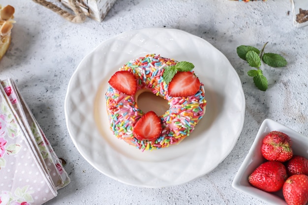 Rosquilla dulce con chispitas de colores y fresas