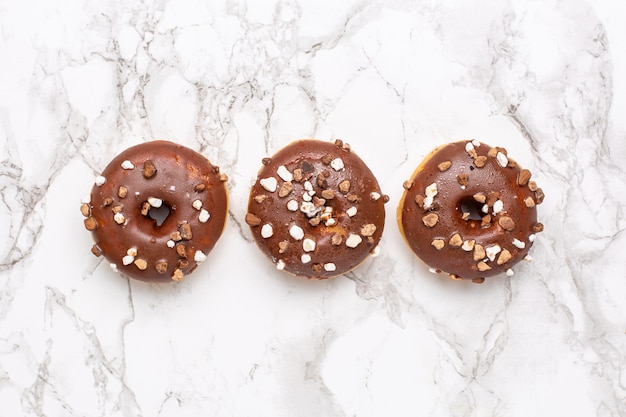 Rosquillas de chocolate dulce en la superficie de mármol aislado plano, minimalismo, comida