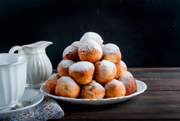 Rosquillas dispuestas pirámide espolvoreada con azúcar en polvo en la oscuridad,