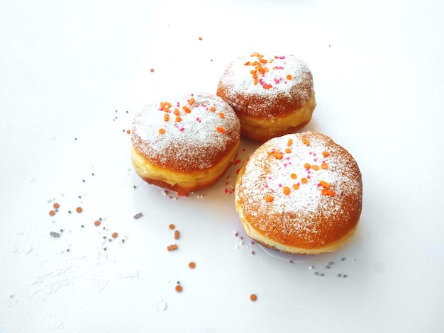 Rosquillas fritas con azúcar en polvo y chispas de confitería de colores